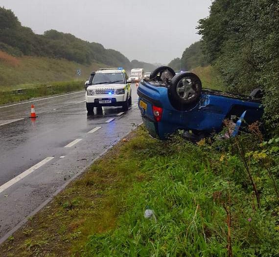 Car ends up on roof in heavy rain on A38