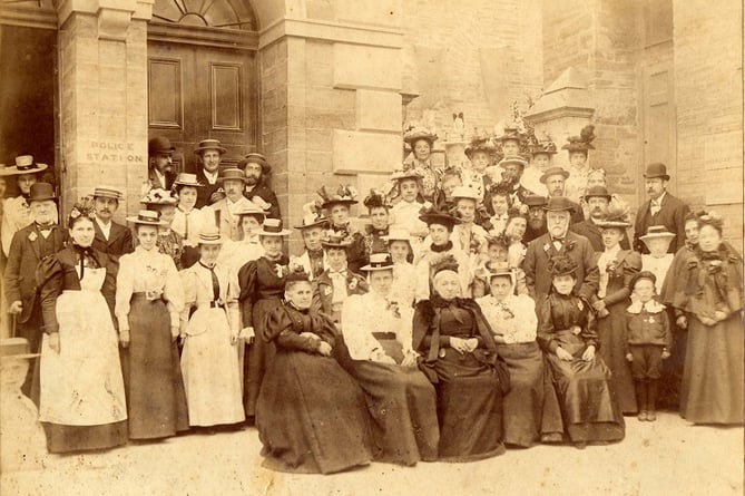 Approximately 50 Ladies and Gentlemen and one child posed outside Town Hall Fore Street, Kingsbridge.   
May be Edward VII Accession. 