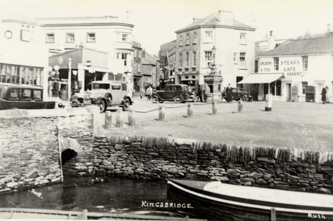 Head of Kingsbridge estuary around 1930, walls and granite bollards.  Note presence of drinking fountain at road junction.  Ryeford Garage on left.  Stone bollards removed every year for the fair. 