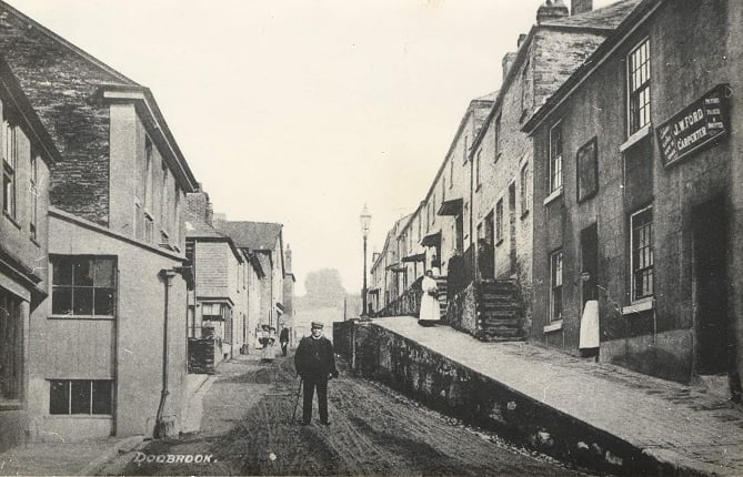 Church Street, Kingsbridge, man standing in the middle of the road.
This area was originally known as Dodbrooke, ‘a town consisting of a scattering of indifferent houses extending about half a mile from the church to the rivulet’.