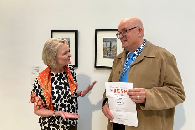 Artist Chris Stone receives his certificate from Alison Mackenzie from the Brownston Gallery