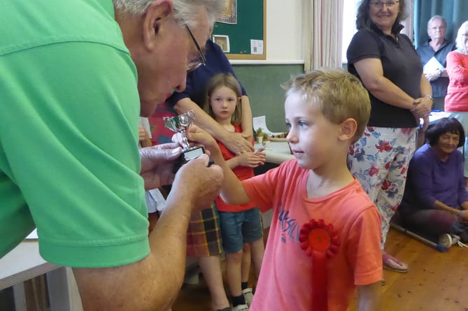 William Coleman receives the Under 8s cup from Tom Gilkes