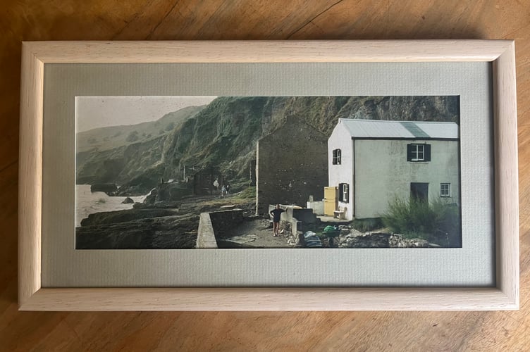 A framed photo of Pebble Cove cottage