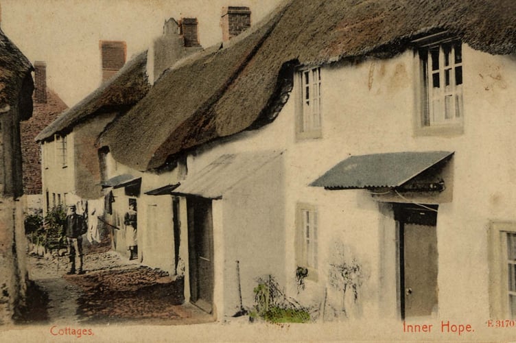 The cottages in the square, Inner Hope, showing man with cap and stick, woman in doorway.  