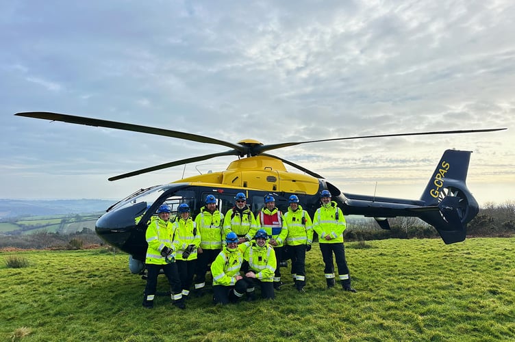 A team photo in front of the helicopter